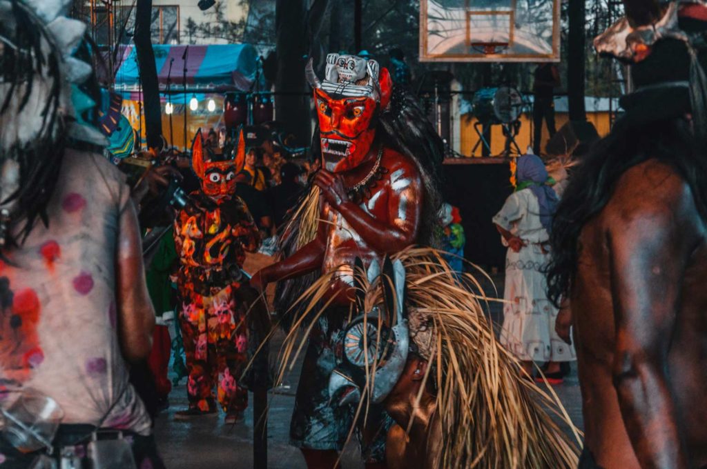 Mexican Man Wearing Red Demon Mask & Covered In Red Oil, Dancing In Carnival