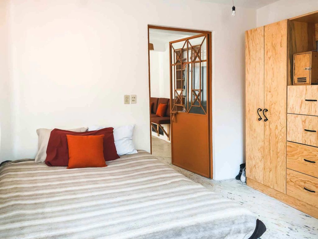 Bedroom Of An Airbnb with white walls and teak cupboards In Mexico's San Miguel De Allende