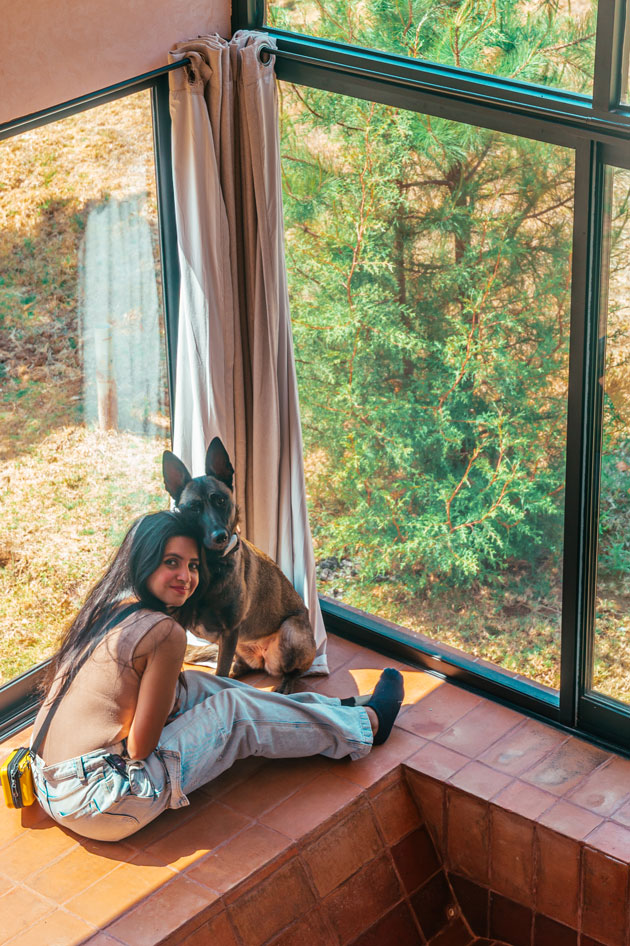 Indian girl with her pet black Belgian Malinois sitting next to a pink Hot Tub.