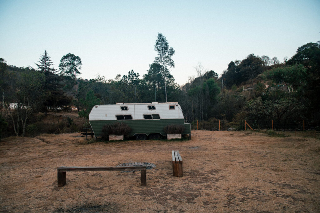 Campervan Parked in a open space with a fireplace and benches