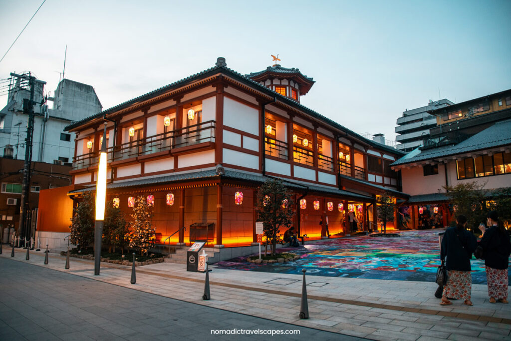 Entrance of Matsuyama's Asuka-no-Yu onsen, lit up with lanterns at twilight