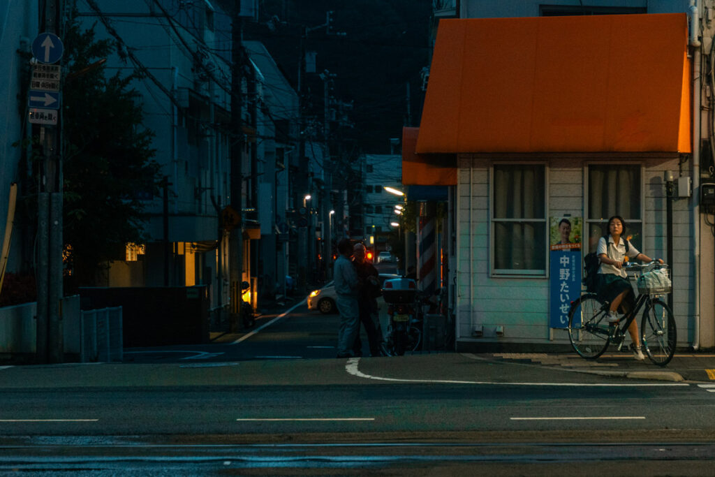 Nightview of Matsuyama City's main street with a school girl on her bicycle 